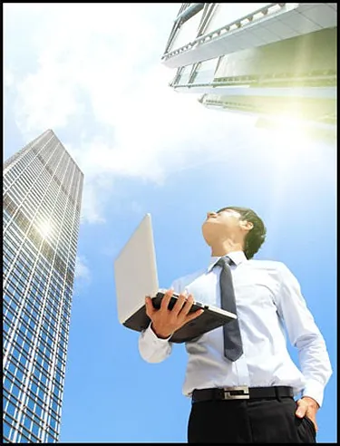 Man with Laptop Looking at Building